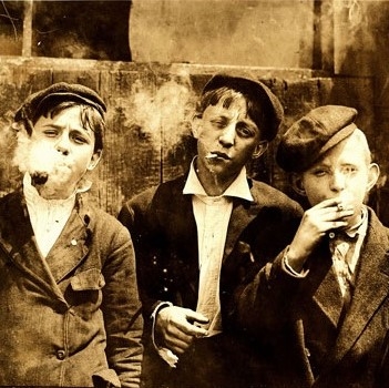 Photo d'époque représentant 3 jeunes garçons fumant cigarettes et pipes