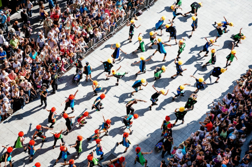 photo de danseurs lors du Défilé de la Biennale sur la rue de la République avec des perruques jeunes et oranges